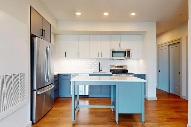 a kitchen with granite countertop a refrigerator stove top oven and sink