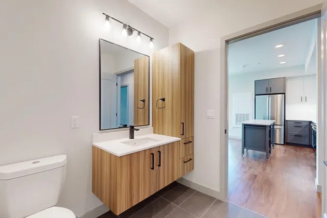 a bathroom with a double vanity sink a mirror and a toilet