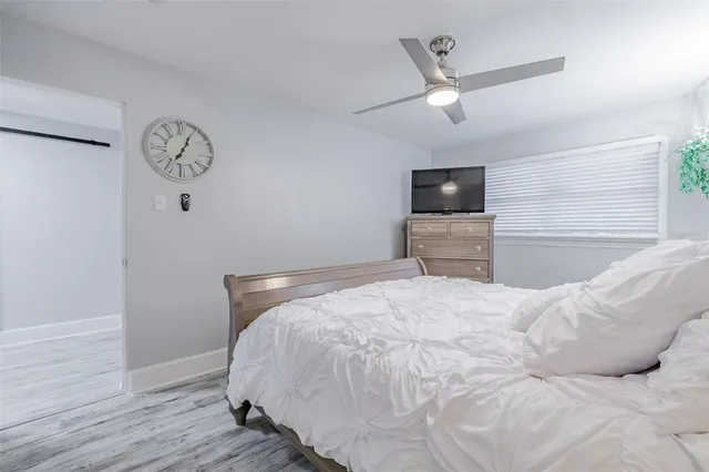 a bedroom with a bed and a large mirror with wooden floor
