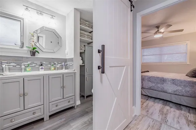a en suite bathroom with a granite countertop sink and a mirror
