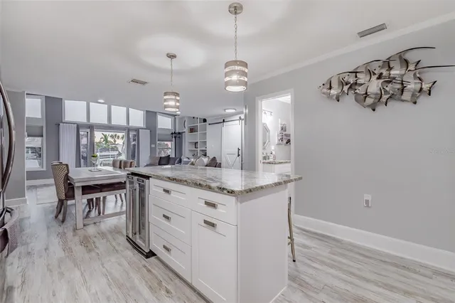a kitchen with granite countertop a stove a sink and a wooden floor