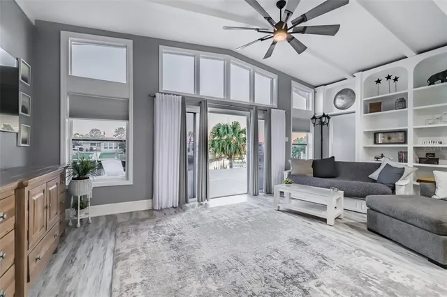 a living room with furniture a flat screen tv and a large window