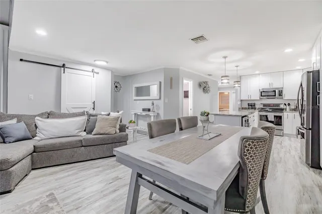 a living room with furniture a refrigerator and kitchen view