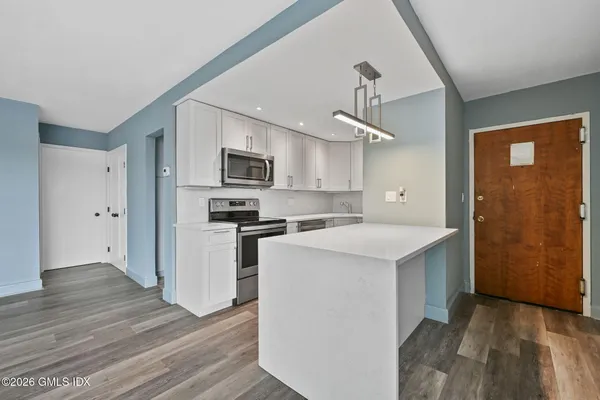 a kitchen with a stove a refrigerator and a microwave