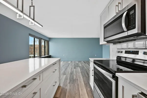 a kitchen with stainless steel appliances granite countertop a stove and a microwave