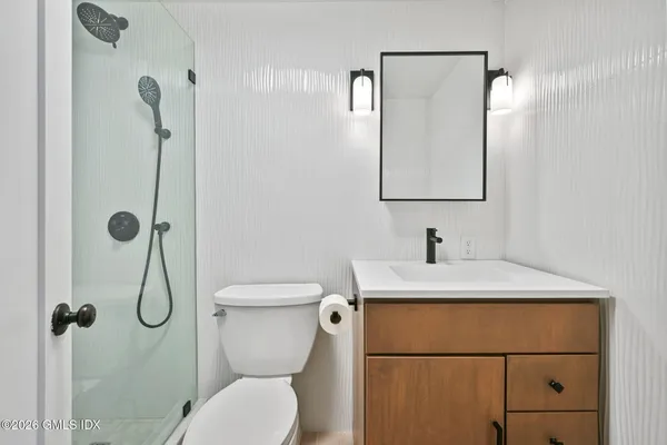 a bathroom with a toilet sink vanity and mirror