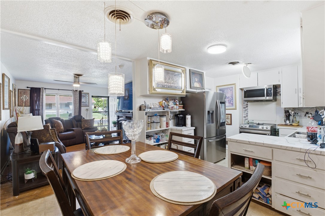 503 Cardinal Avenue Killeen, TX 76541 - Photo 10 of 26 a kitchen with sink refrigerator dining table and chairs