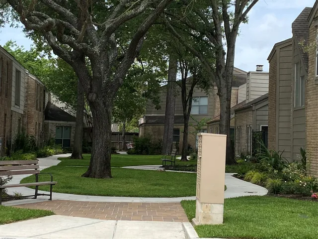 a front view of a house with a yard and large trees