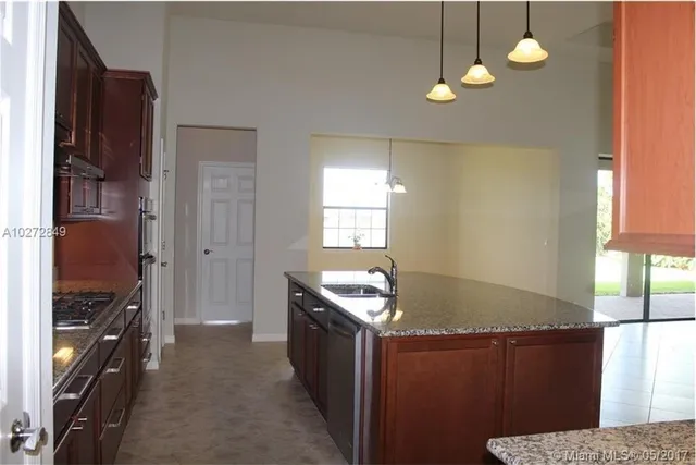 a kitchen with granite countertop a stove and a refrigerator
