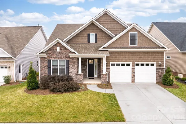 a front view of a house with yard garage and outdoor seating