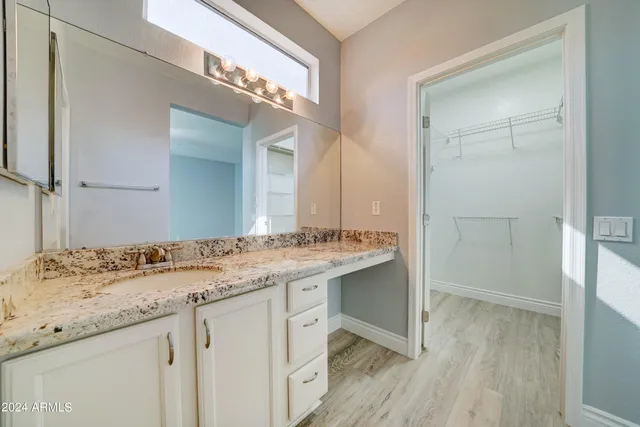 a bathroom with a granite countertop sink a mirror and a shower