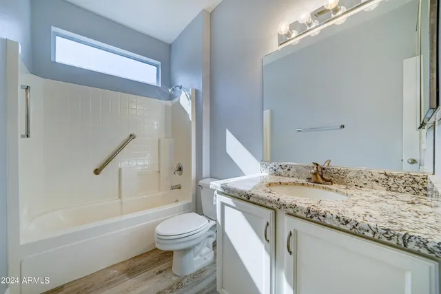 a bathroom with a granite countertop sink toilet and shower
