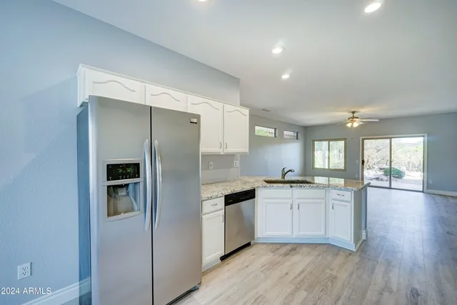 a kitchen with granite countertop stainless steel appliances a sink and cabinets