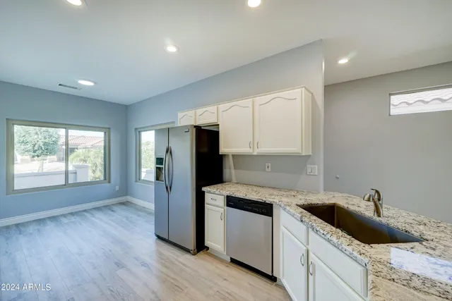 a kitchen with a sink a refrigerator and window