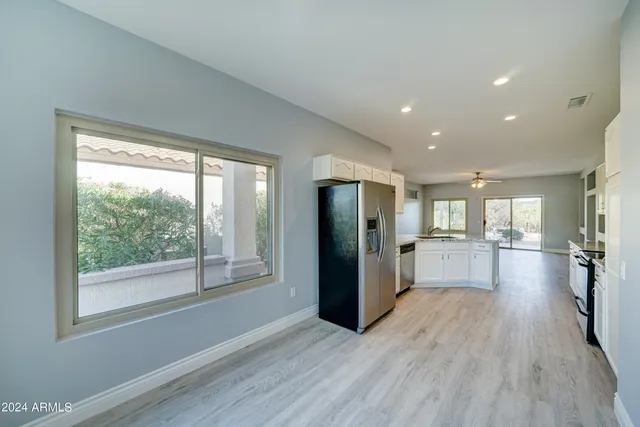 a view of a kitchen with refrigerator and wooden floor