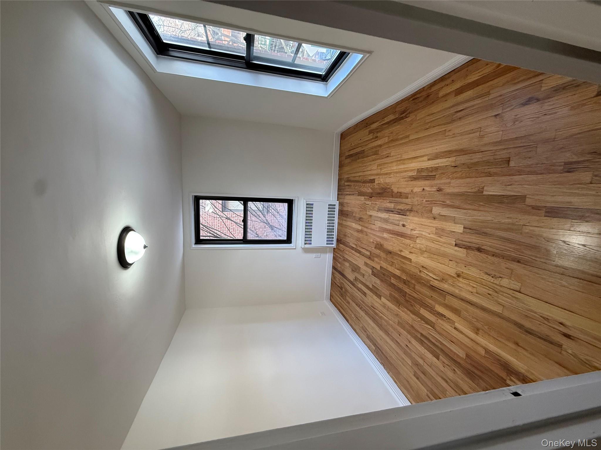 83-40 Austin Street, Unit 3U Queens, NY 11415 - Photo 2 of 8 wooden floor in an empty room with a window