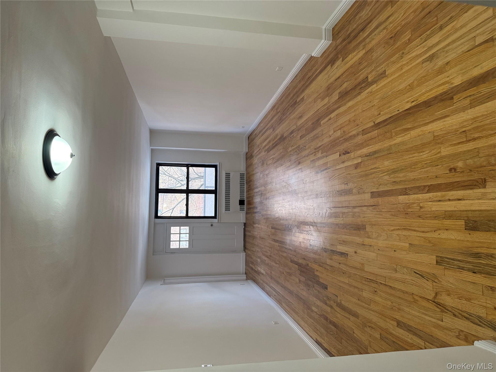 83-40 Austin Street, Unit 3U Queens, NY 11415 - Photo 5 of 8 wooden floor in an empty room with a window