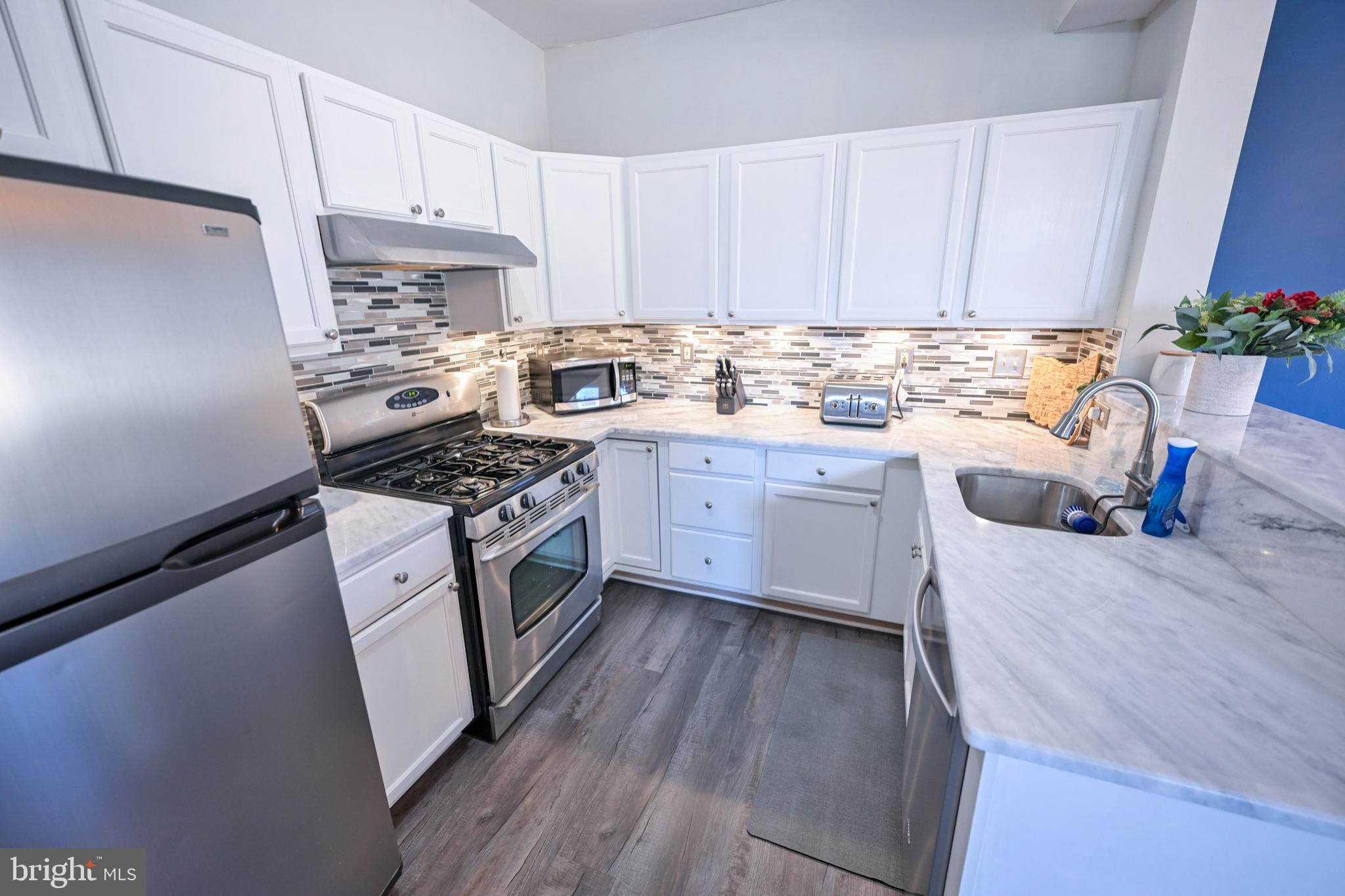 8727 Grape Arbor Way Odenton, MD 21113 - Photo 13 of 49 a kitchen with granite countertop a sink a stove and cabinets