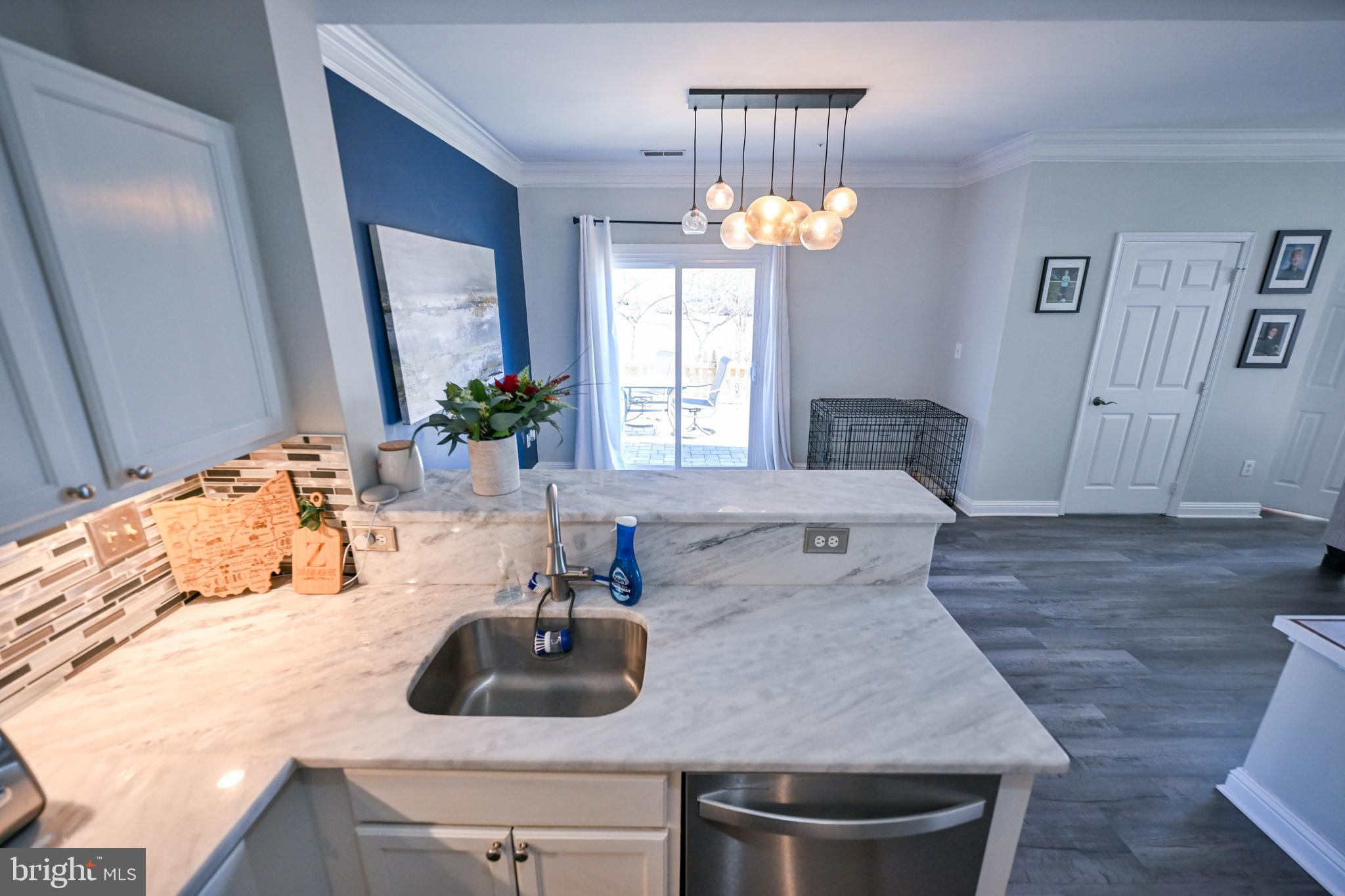 8727 Grape Arbor Way Odenton, MD 21113 - Photo 14 of 49 a view of a kitchen island a sink wooden floor and a chandelier