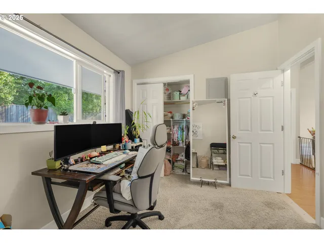 a view of a workspace with furniture and a window