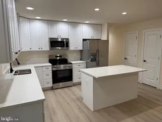 a kitchen with a sink a refrigerator a microwave and cabinets