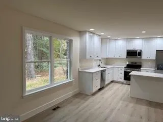 a kitchen with sink a microwave and cabinets