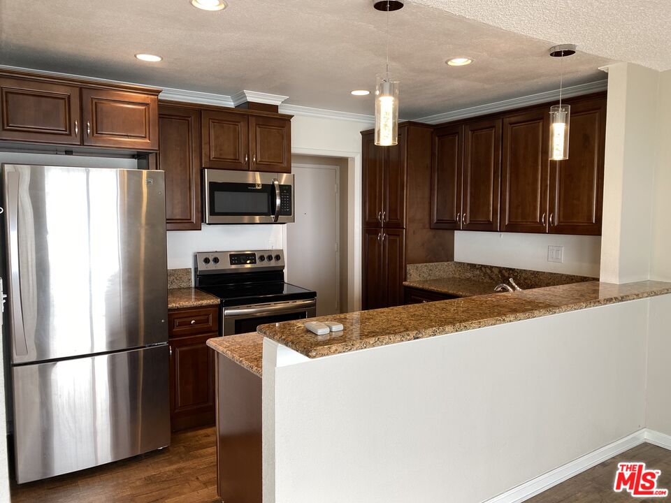 18000 Coastline Drive, Unit 8 Malibu, CA 90265 - Photo 7 of 26 a kitchen with kitchen island a counter top space stainless steel appliances and cabinets
