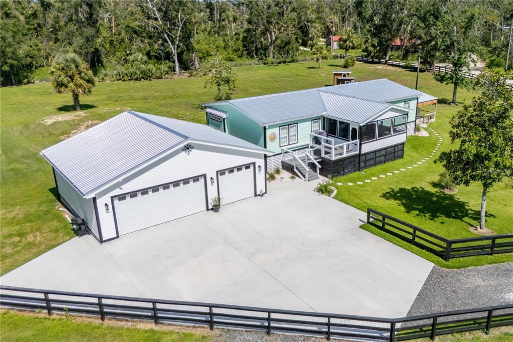 an aerial view of a house with swimming pool garden and trees