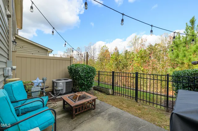 a view of a chair and tables in the back yard of the house