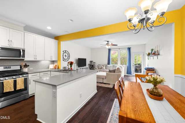 a kitchen with stainless steel appliances granite countertop a sink dishwasher stove and refrigerator with wooden floor