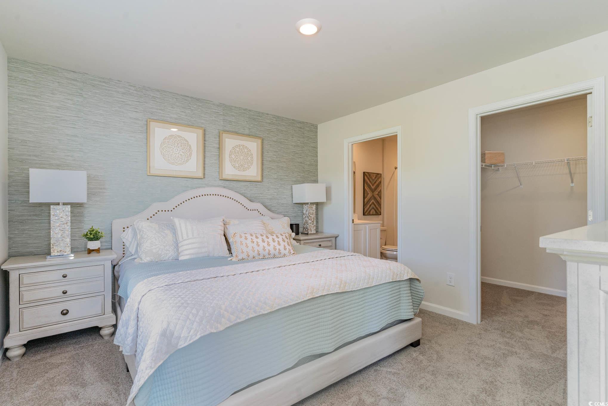 243 Teddy Bear Loop Conway, SC 29526 - Photo 14 of 24 Bedroom featuring an accent wall, light carpet, a spacious closet, and wallpapered walls