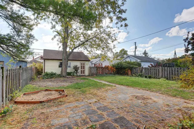a view of a big yard next to a house with wooden fence