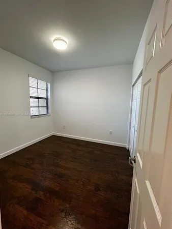 an empty room with wooden floor and closet