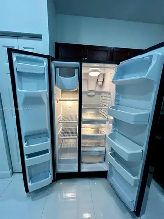 a view of kitchen with stainless steel appliances a refrigerator sink and microwave