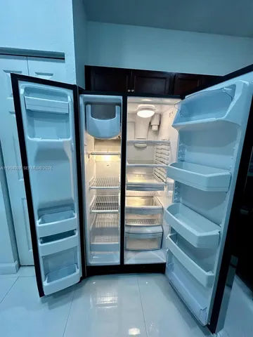 a view of kitchen with stainless steel appliances a refrigerator sink and microwave