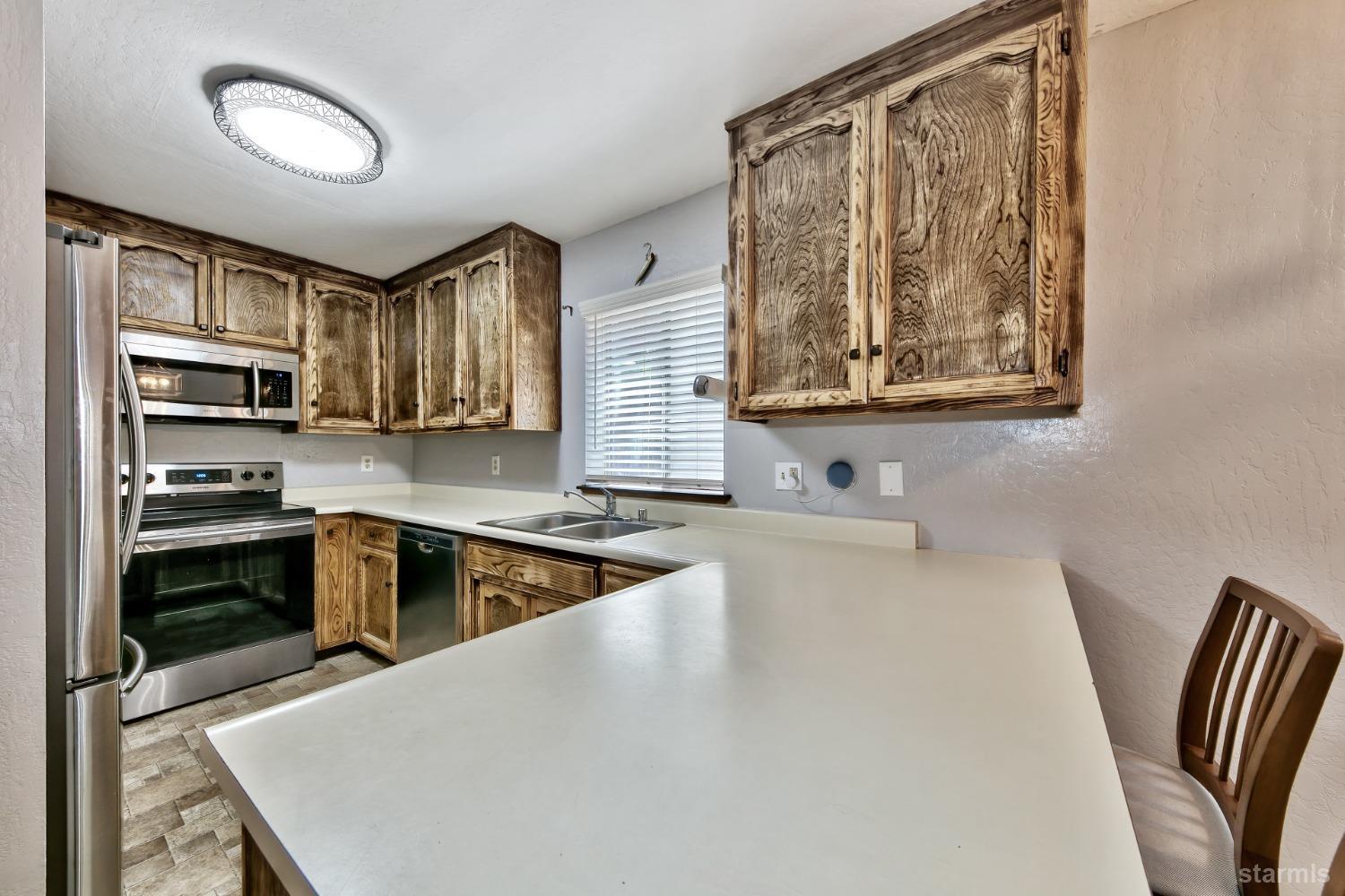 167 Tramway Drive, Unit B Stateline, NV 89449 - Photo 5 of 15 a large kitchen with a stove a sink and a microwave