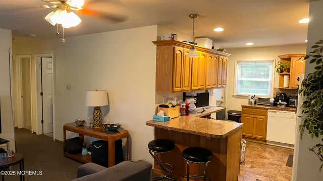 a view of a dining room with furniture a chandelier and a large window