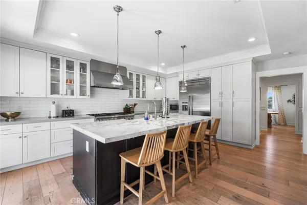 a kitchen with a dining table chairs sink and cabinets