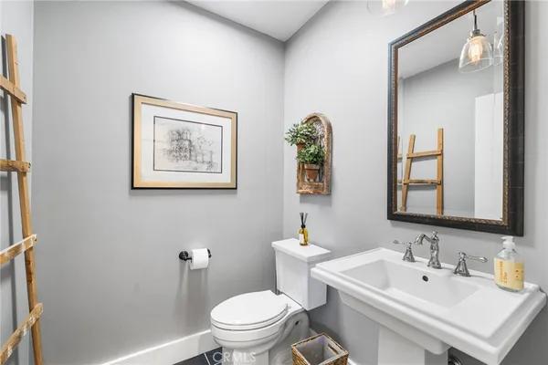 a bathroom with a toilet a sink and mirror