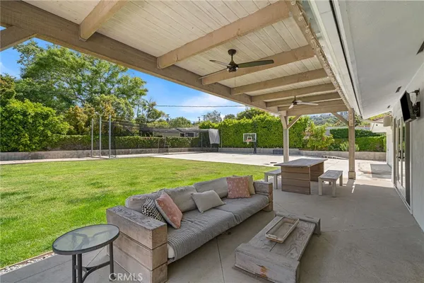 a view of a swimming pool with a couches chairs and a yard