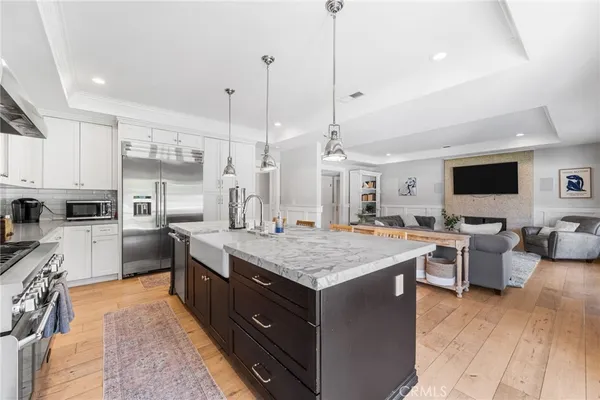 a large kitchen with stainless steel appliances kitchen island granite countertop a large center island a stove a sink a dining table and chairs