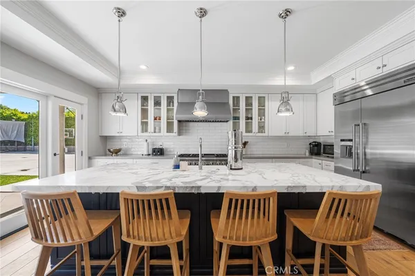 a kitchen with stainless steel appliances granite countertop a kitchen island a table and chairs