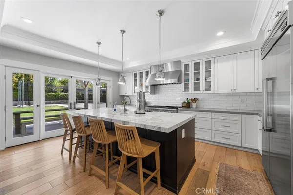 a kitchen with kitchen island granite countertop a table chairs stove and refrigerator