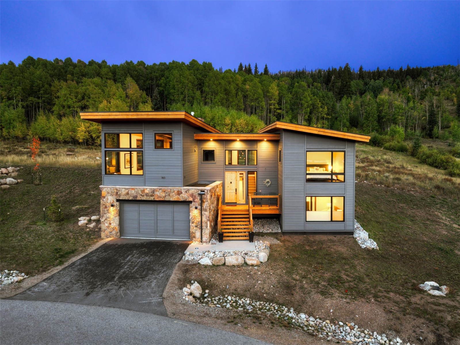 160 Vendette Road Silverthorne, CO 80498 - Photo 1 of 50 Modern home with a deck, a forest view, driveway, and stone siding