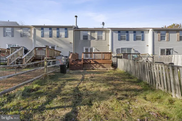 a view of a big house with wooden fence
