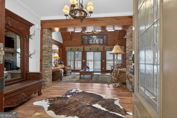 a view of a dining room with furniture a chandelier and wooden floor