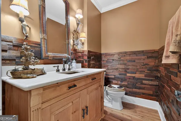 a kitchen with stainless steel appliances granite countertop a refrigerator a sink dishwasher a stove and a dining table with wooden floor