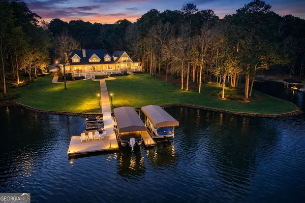 an aerial view of a house with a yard and large trees