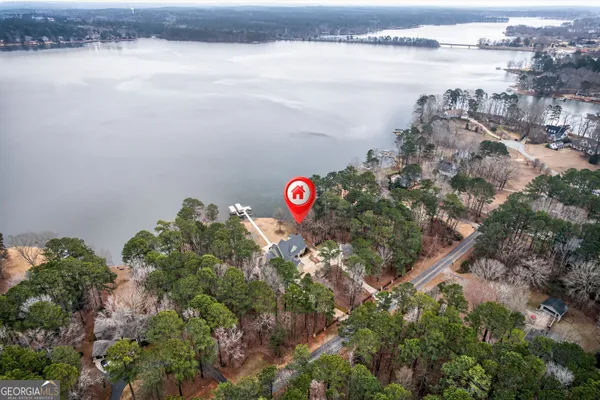an aerial view of a house with a yard and lake view