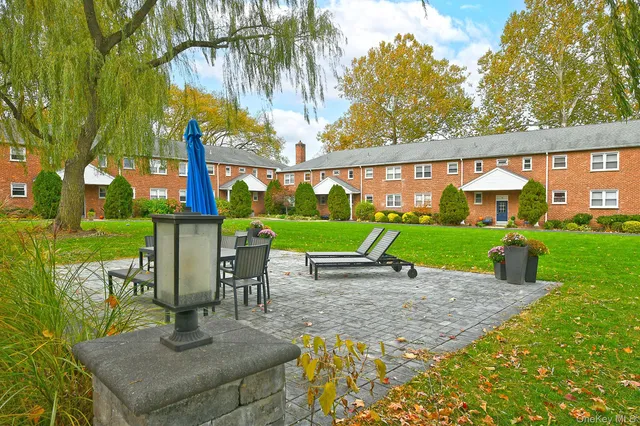 a view of a house with a yard and sitting area